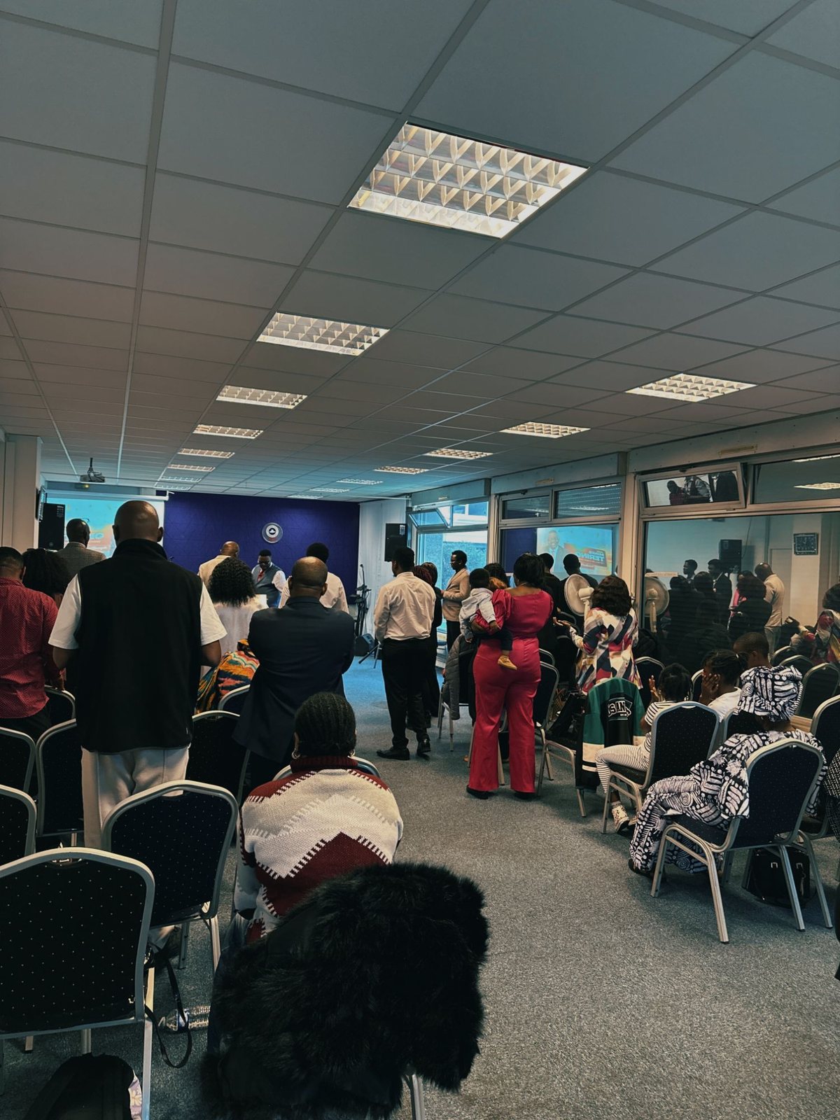 The congregation standing in worship during a service at True Vine Parish